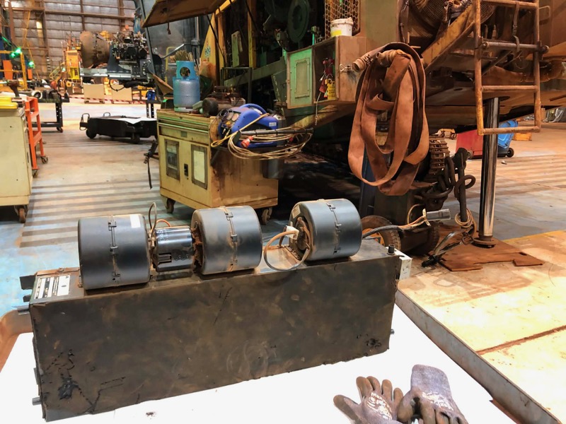 Vehicle fan motors and components arranged on a workshop bench